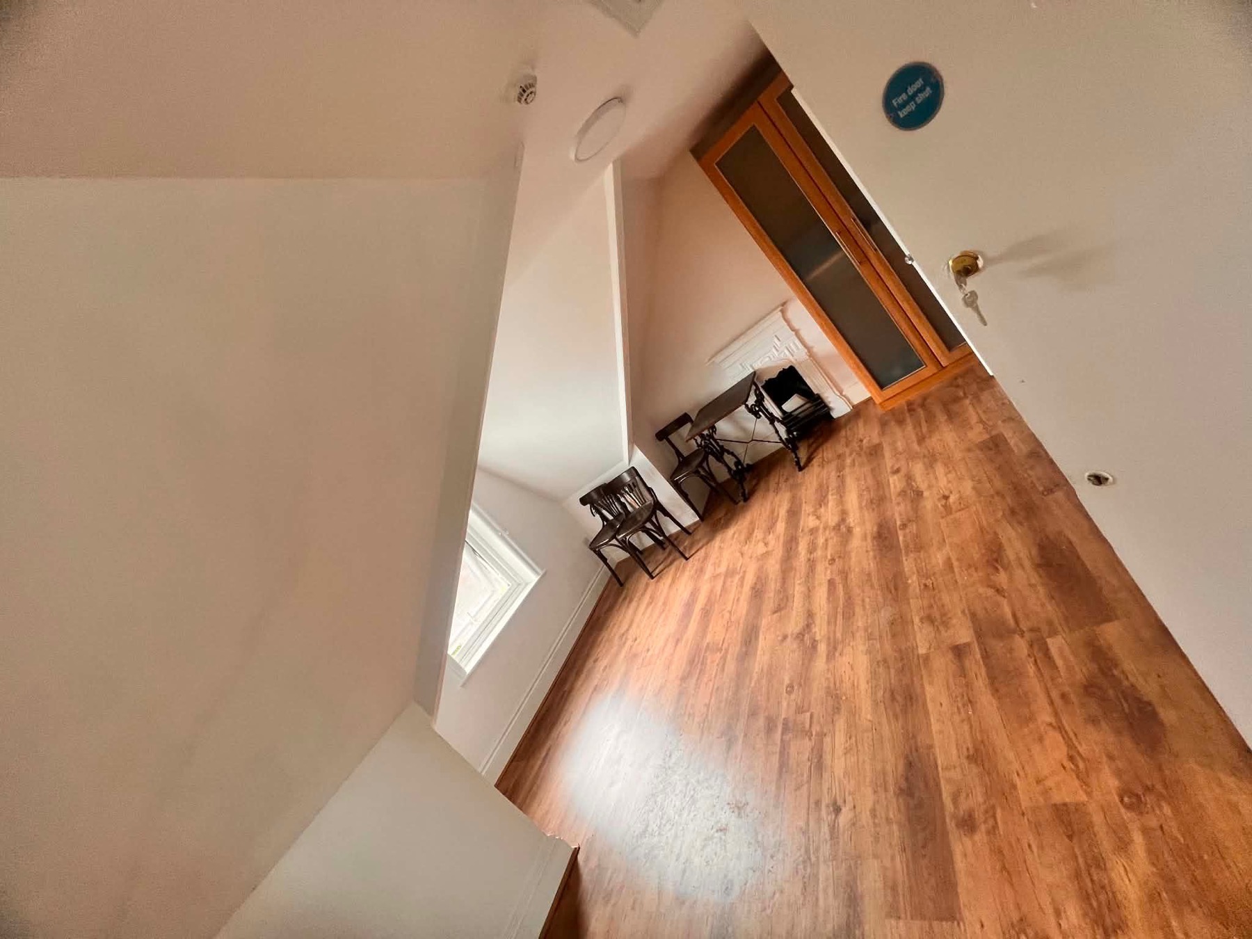 Room and kitchen view with wood flooring